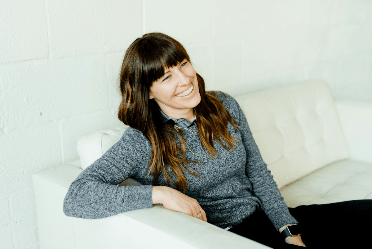 Woman smiling and sitting on a white sofa