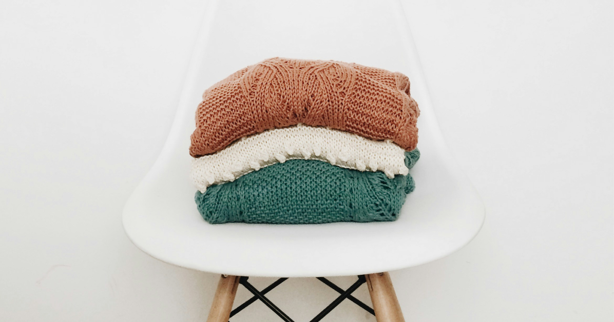 Terracotta and warm teal sweaters on a chair